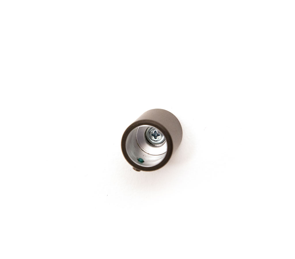 Close-up of standoff barrel hardware installed on a wall.