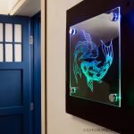 Clear acrylic engraved with a fish, mounted to the wall using Gyford LED Standoffs
