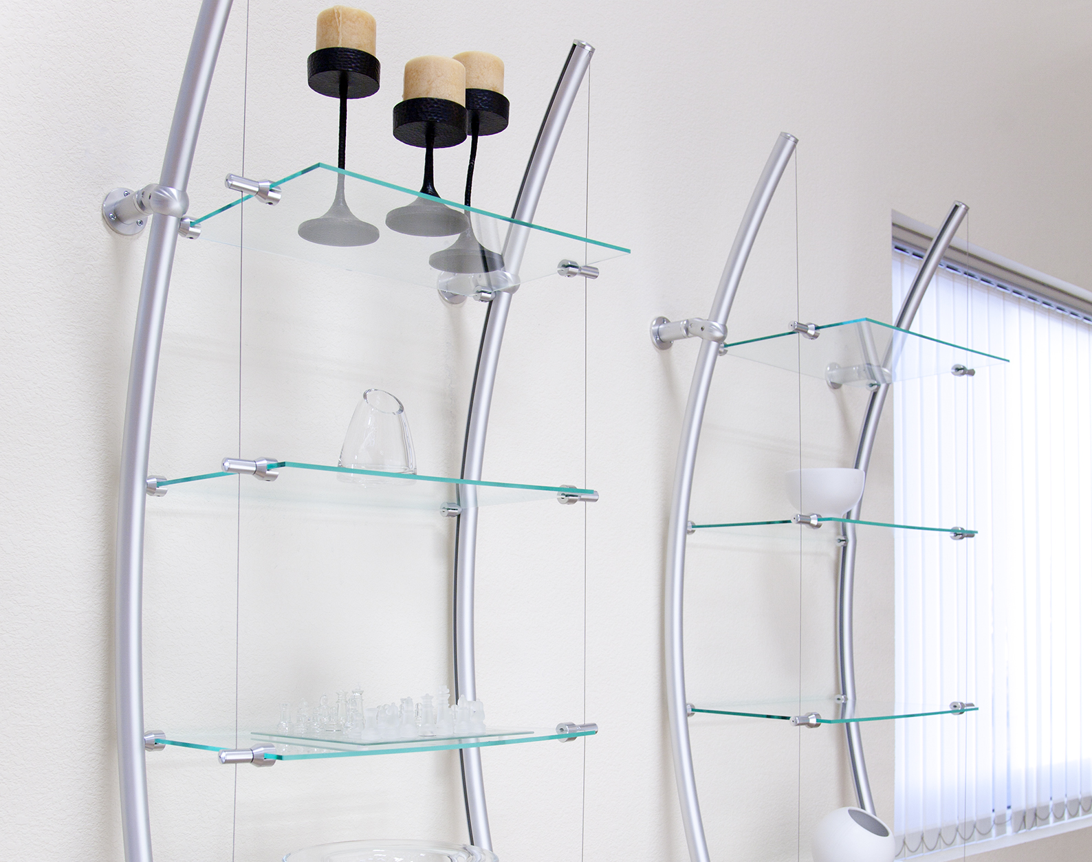 Glass shelves mounted with metal rods, wire supports, and standoff hardware.
