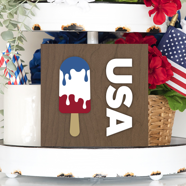 Tiered tray with patriotic decor and TruFlat wood sign that has a red, white and blue popsicle and text that says "USA" using Craft Plastic