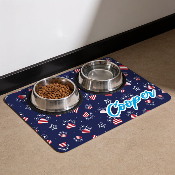 floor mat with patriotic pawprint and the name Cooper printed on it with dog water and food bowls sitting on it