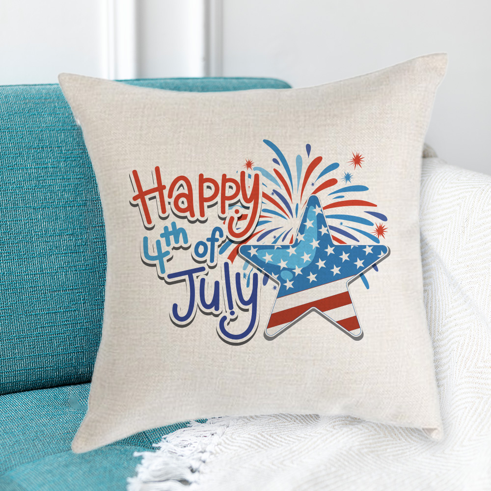 Linen pillow case on a teal couch with print on it that says "Happy 4th of July" and an American flag star