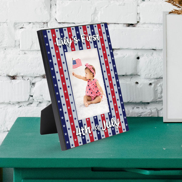 UN1019 MDF patriotic background picture frame with a baby girl sitting on the beach in a patriotic outfit. Frame says Lily's First 4th of July