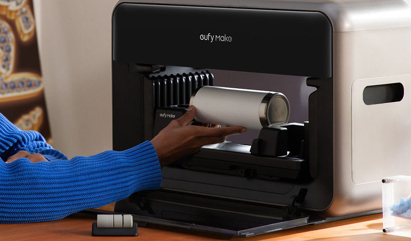 person inserting a white tumbler into the rotary attachment on an eufyMake UV printer