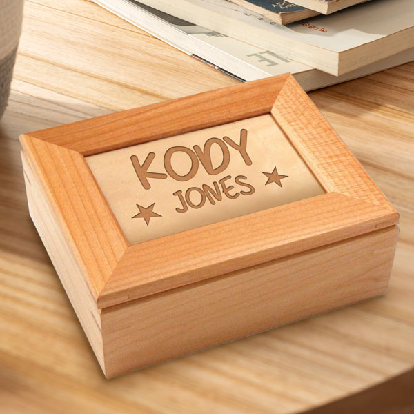 Wood keepsake box sitting on a table. Box engraved to say Kody Jones with stars