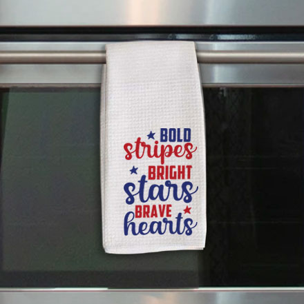 White waffle weave towel with red and blue quote that says "Bold stripes bright stars brave hearts"